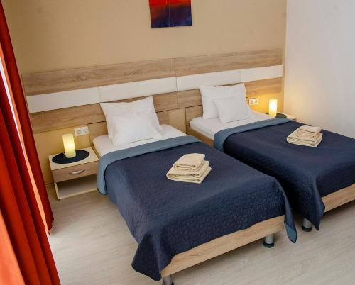 a hotel room with two beds with towels on them at Hotel Pallone in Balatonfüred
