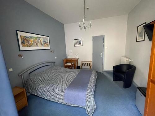 a bedroom with a bed and a table and a chair at Hôtel Adour in Pau