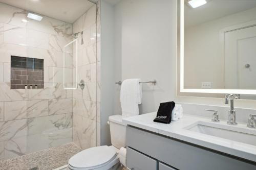 a white bathroom with a toilet and a sink at The Eleanor New Orleans in New Orleans