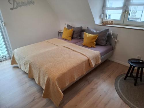 a bedroom with a bed with yellow and gray pillows at Blickpunkt in Feucht