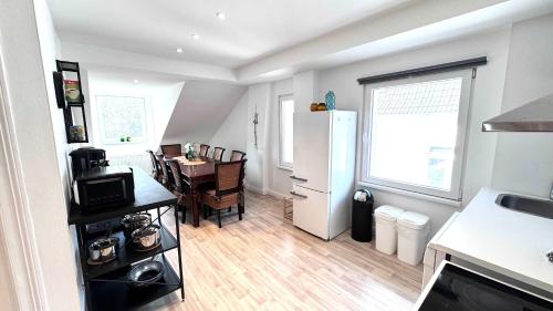 a kitchen with a table and a white refrigerator at Loft Hof Hamburg Central near UKE NDR ZOO in Hamburg