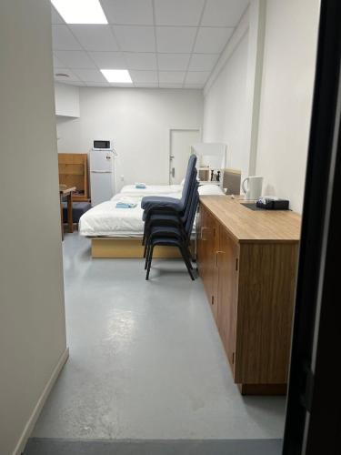 a hospital room with a bed and a desk and chairs at 2 Double Beds, 1 Single Bed, 2 Double Sofa Beds in 1 Room, Serviced Suite 6 in Auckland