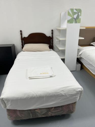 a bedroom with a bed with a white blanket at 2 Double Beds, 1 Single Bed, 2 Double Sofa Beds in 1 Room, Serviced Suite 6 in Auckland