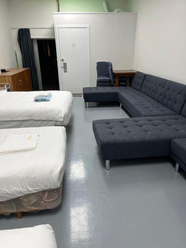 a living room with two beds and a couch at 2 Double Beds, 1 Single Bed, 2 Double Sofa Beds in 1 Room, Serviced Suite 6 in Auckland
