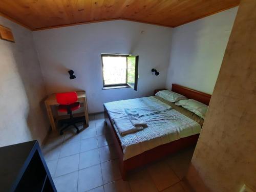 a bedroom with a bed and a desk and a window at Rooms Vid&Rok in Mošćenička Draga