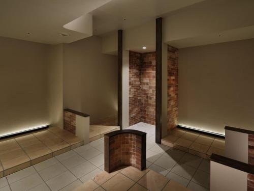a lobby with a brick wall and a brick pillar at Kobe Minato Onsen Ren in Kobe