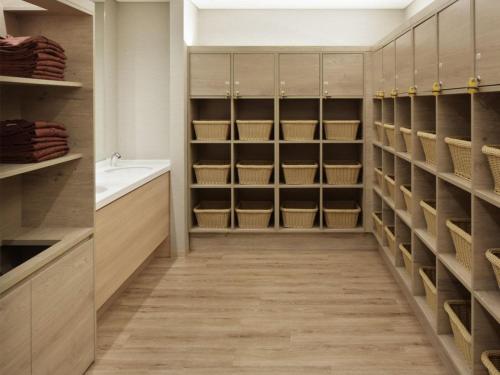 a walk in closet with a sink and a tub at Kobe Minato Onsen Ren in Kobe