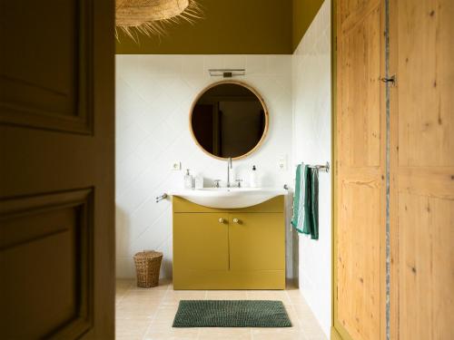 une salle de bain avec un lavabo et un miroir dans l'établissement LE DOMAINE DE FERRAT, à Mirambeau