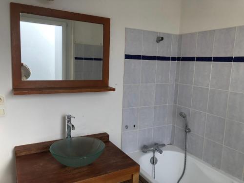 La salle de bains est pourvue d'un lavabo et d'une baignoire. dans l'établissement Le Voyageur Sur le sable du samedi au samedi pendant les vacances scolaires, à Berck-sur-Mer