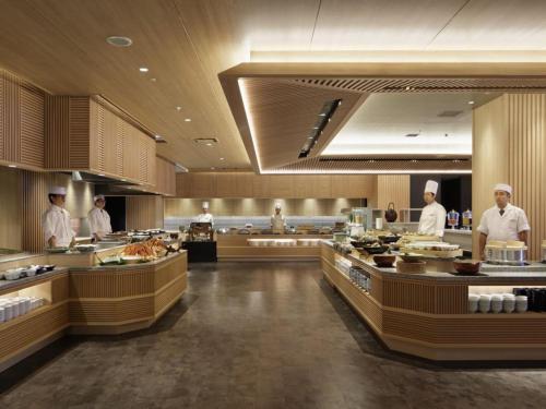 a kitchen with chefs preparing food in a restaurant at Kobe Minato Onsen Ren in Kobe