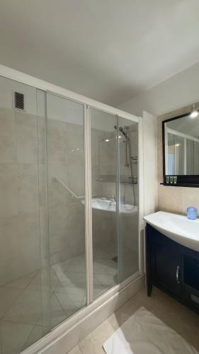une salle de bain avec une douche en verre et un lavabo dans l'établissement Cosy two bedroom apartment near the Eiffel Tower, à Paris