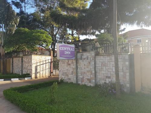 a sign on a brick fence in front of a house at Central inn Hotel in Entebbe