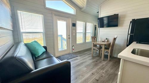 a living room with a leather couch and a table at Waterfront on the Bay & Close to Beach -Brand New! in Bolivar Peninsula