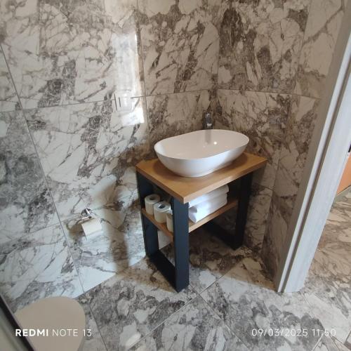 a bathroom with a sink and a marble wall at Melek in Medulin