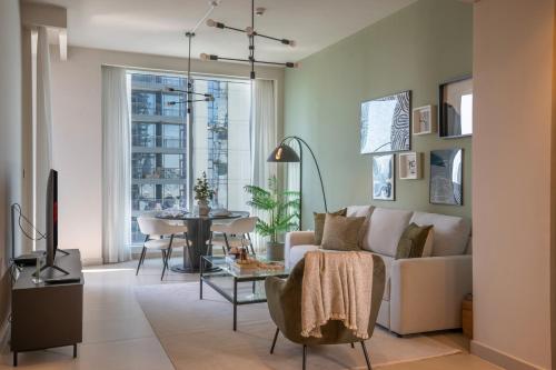 a living room with a couch and a table at Stylish 1BR with Dubai Skyline & Burj Khalifa View in Dubai