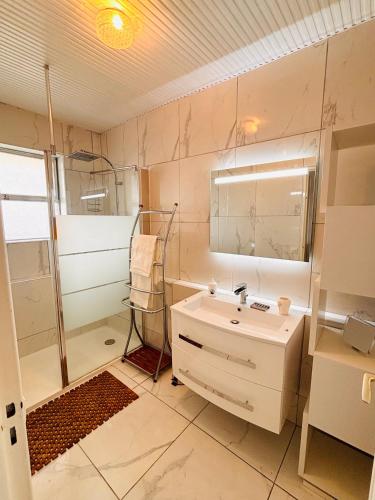 une salle de bain avec un lavabo et une douche dans l'établissement Marina Baie des Anges - Studio - Villeneuve-Loubet, à Villeneuve-Loubet