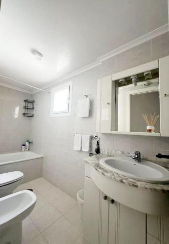 a bathroom with a sink and a toilet and a mirror at Holiday Apartment in Torrevieja