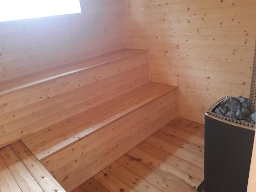a wooden sauna with a bench in the corner at Duhová sova in Jílové u Držkova