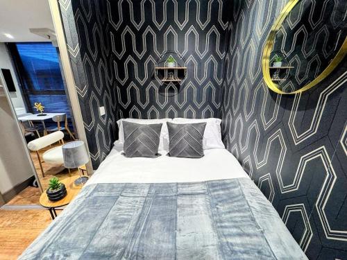 a bedroom with a bed in a room with a wall at Luxury Studio Suite Town Centre Short Stay in Maidstone