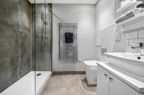 a bathroom with a shower and a toilet and a sink at Luxury Studio Suite Town Centre Short Stay in Maidstone