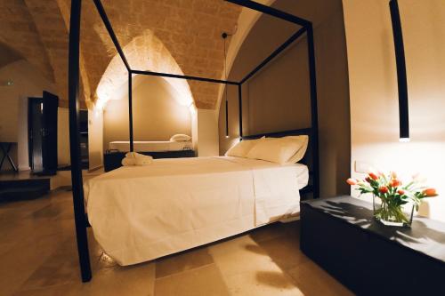 a bedroom with a white bed with a black frame at La Dimora di Cesare Braico in Brindisi