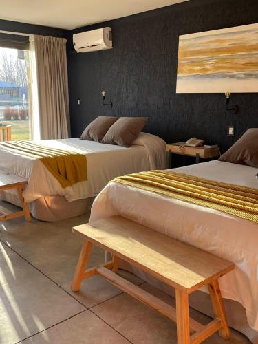 two beds in a hotel room with two benches at Casa Septem in Villa Seca