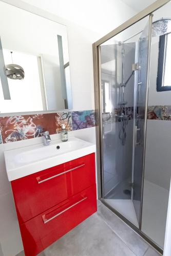 La salle de bains est pourvue d'une armoire rouge et d'une douche. dans l'établissement Beautiful home for 2-8 people with a pool, à Roquefort-la-Bédoule