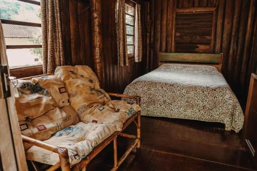 une chambre avec un lit dans une pièce en bois dans l'établissement Chalé Sanga, à Jaraguá do Sul