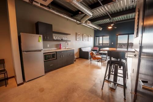 a kitchen with a refrigerator and a table and chairs at Brewhalla Hotel in Fargo
