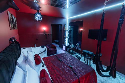 a red room with a bed and a tv at Romeo Nights - Love Rooms - Adults Only in Bucharest