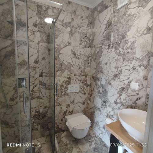 a bathroom with a shower and a toilet and a sink at Melek in Medulin