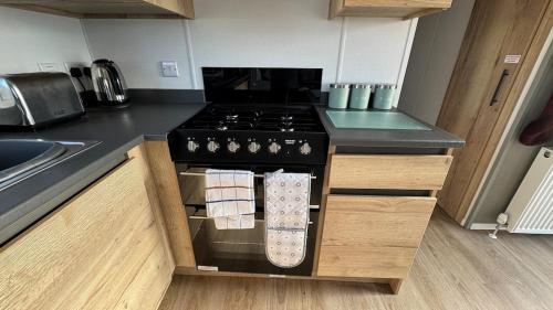 a kitchen with a stove top oven in a kitchen at Modern Caravan 2 Bedrooms Sleeps 6 near Weymouth in Wyke Regis