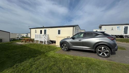 a silver car parked in front of a house at Modern Caravan 2 Bedrooms Sleeps 6 near Weymouth in Wyke Regis