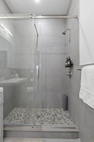 a shower with a glass door in a bathroom at Modern Retreat Free Parking 30Min NYC in Bayonne