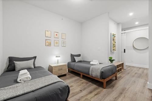 a bedroom with two beds and a mirror on the wall at Modern Retreat Free Parking 30Min NYC in Bayonne