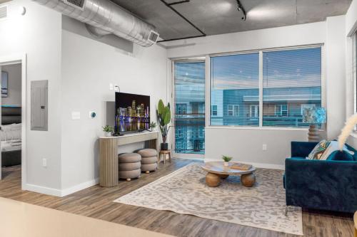 a living room with a blue couch and a table at Spacious 2BR Retreat Perfect for Tropicana Events in St. Petersburg