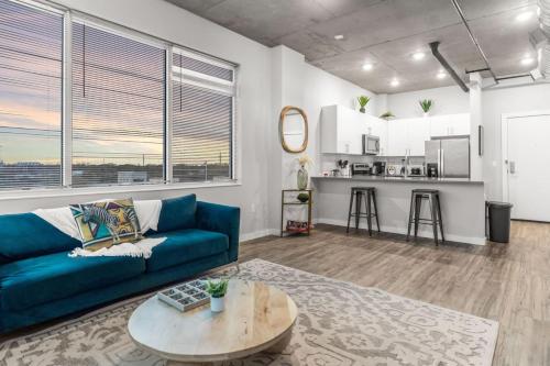 a living room with a blue couch and a table at Spacious 2BR Retreat Perfect for Tropicana Events in St. Petersburg