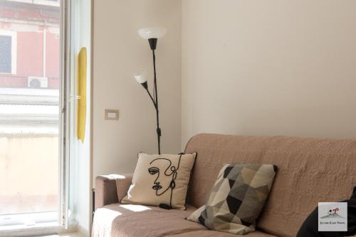 a living room with a couch and a lamp at La casa di zia Maria in Pozzuoli
