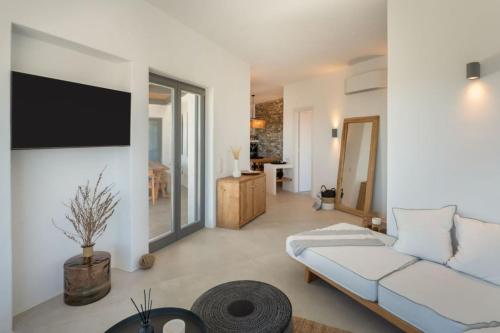 a living room with a couch and a tv at Sunrise Poem Villa 1 in Prodromos Paros