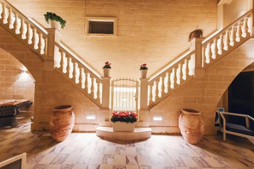 a hallway with stairs and flower pots in a building at La Dimora di Cesare Braico in Brindisi