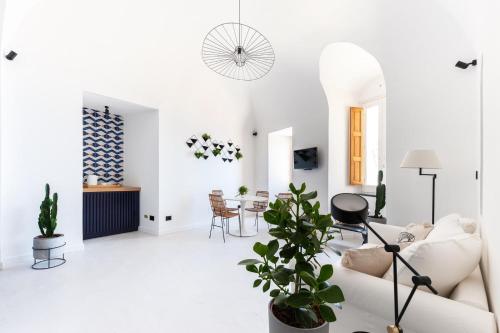 a white living room with a white couch and a table at Casa Tusci Amalfi Sea View Duomo Ferry to Positano in Amalfi