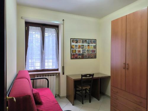 a bedroom with a red couch and a desk and a deskictericter at Casa Vacanze Parco Azzurro - Il tuo angolo di tranquillita' ai Castelli Romani in Monte Compatri