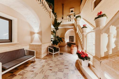 an ornate hallway with a staircase and flowers at La Dimora di Cesare Braico in Brindisi