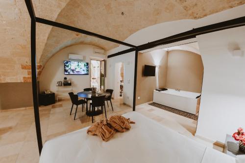 a bedroom and living room with a bed and a table at La Dimora di Cesare Braico in Brindisi