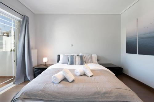 a bedroom with a large bed with two pillows on it at Luxe Bliss 2BR, Glyfada in Athens