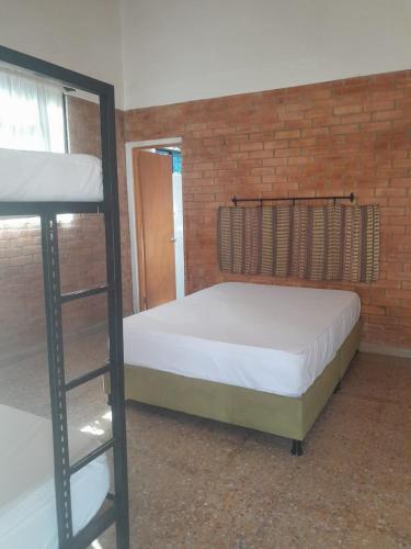 a bedroom with two bunk beds and a brick wall at Casa Campestre con piscina privada- Anapoima in Anapoima