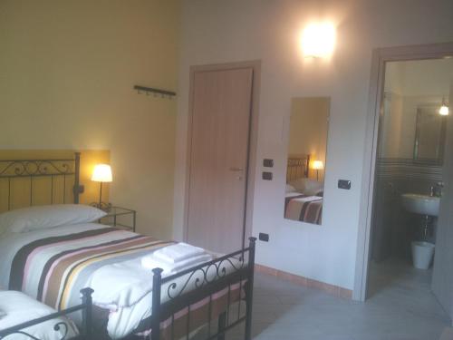 a bedroom with a bed and a bathroom with a sink at B&B Bianchi 64 in Pisa