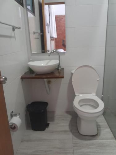 a bathroom with a white toilet and a sink at Casa Campestre con piscina privada- Anapoima in Anapoima