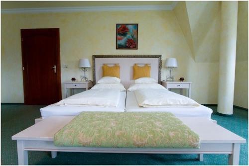 a bedroom with two large beds and a red door at Hétkúti Wellness Hotel in Mór