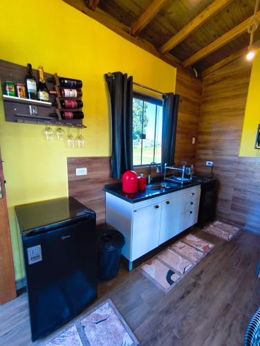 a kitchen with yellow walls and a sink in a room at Horizonte azul sussuarana in Gonçalves
